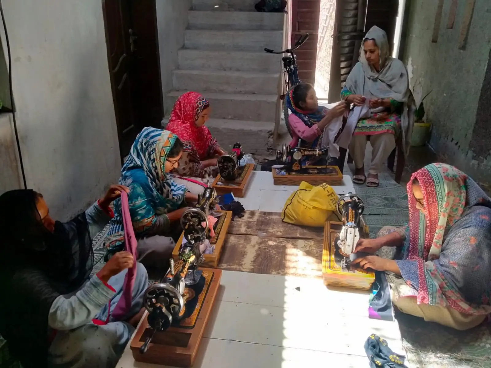 Women working together on sewing machines in a community workshop